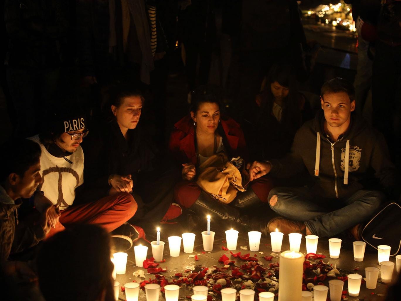 Crowds gather to look at floral tributes and candles left at Place de la Republique (Republic Square), following the terrorist attacks 