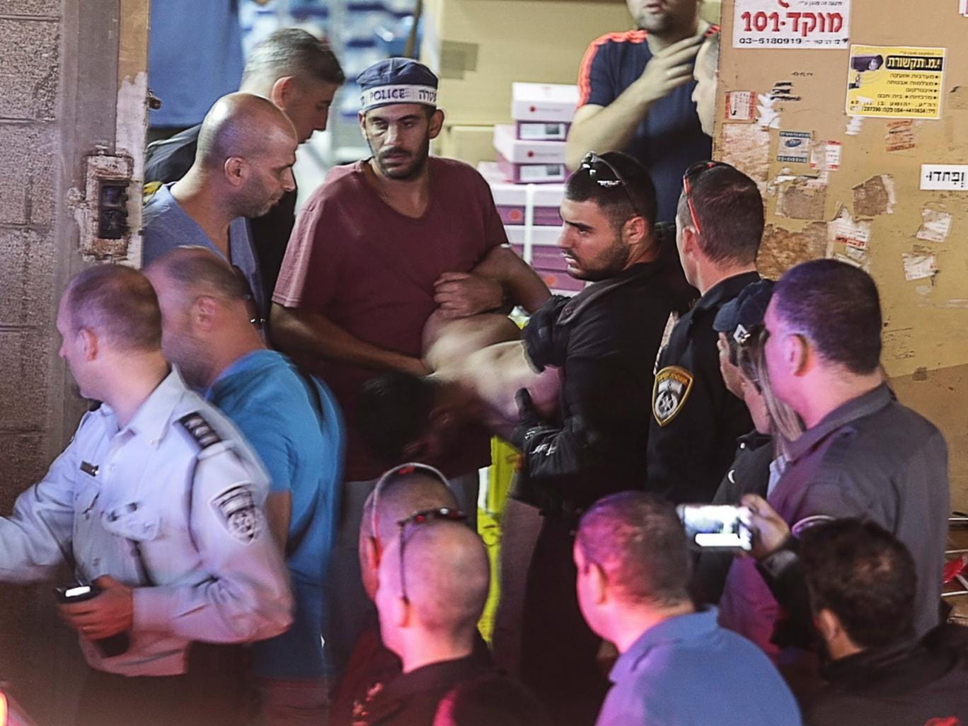 Israeli policemen arrest a Palestinian attacker at the scene of a stabbing attack in Tel Aviv, Israel. Two people were killed and a third injured by an assailant wielding a knife 