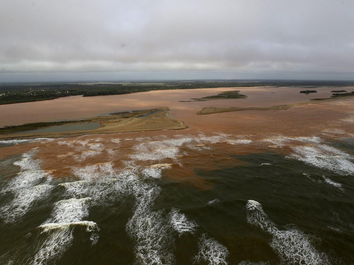 The mouth of the Doce River, flooded with mud after a dam owned by mining firms burst; the disaster has displaced hundreds of people and may affect fish, sea turtles and a coral reef