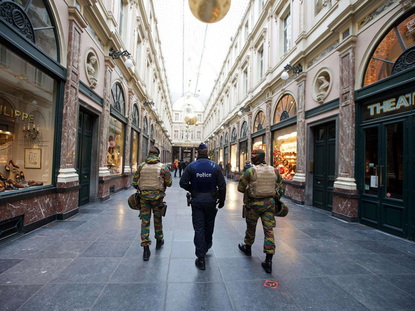 Belgian troops patrol at the Royal Galleries of Saint-Hubert in Brussels. A tense Belgian capital was locked down for a second day with police and troops patrolling deserted streets 