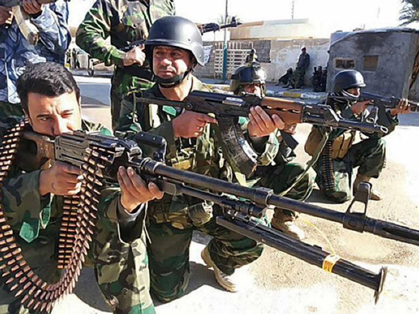 Iraqi troops strike valiant poses outside Ramadi in 2014, prior to an operation to drive out Isis forces holding the city