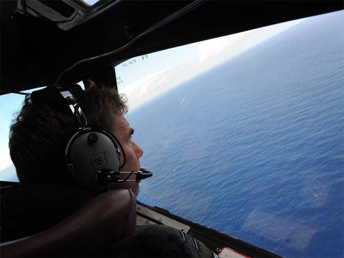  Co-pilot and Squadron Leader Brett McKenzie of the Royal New Zealand Airforce (RNZAF) P-3K2-Orion aircraft, helps to look for objects during the search for missing Malaysia Airlines flight MH370 in flight over the Indian Ocean in April 2014
