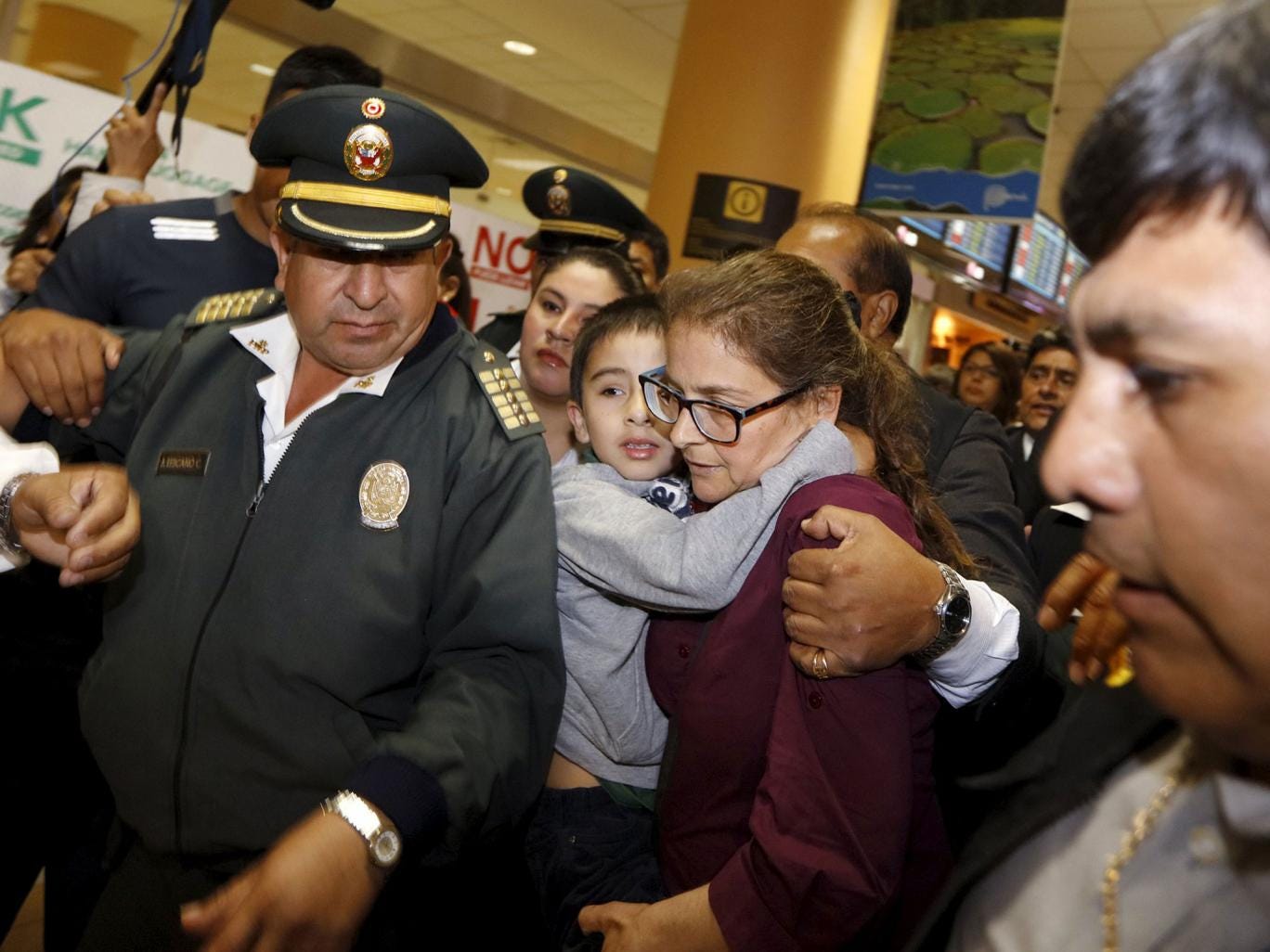 Lori Berenson and her son are escorted by police as she leaves Peru
