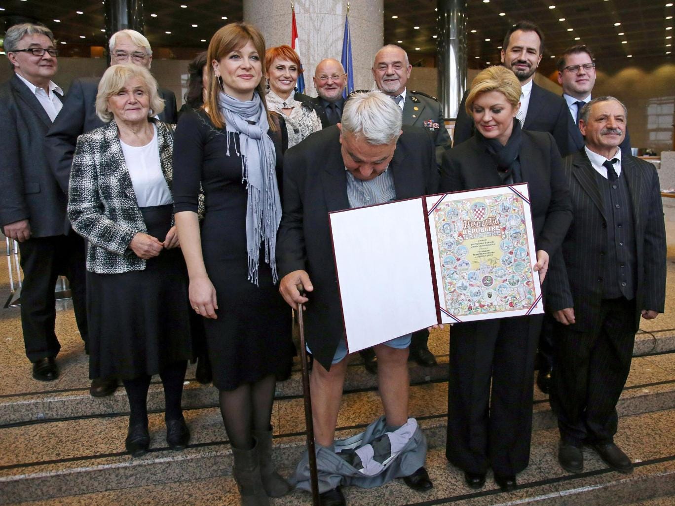Croatia's leading rights group chief Ivan Zvonimir Cicak's looks down after his trousers 