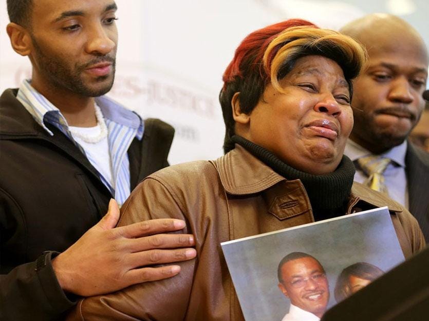 Cynthia Daniels is comforted by her son Bobby Daniels Jr. during a news conference about the death of  her husband, Bobby Daniels