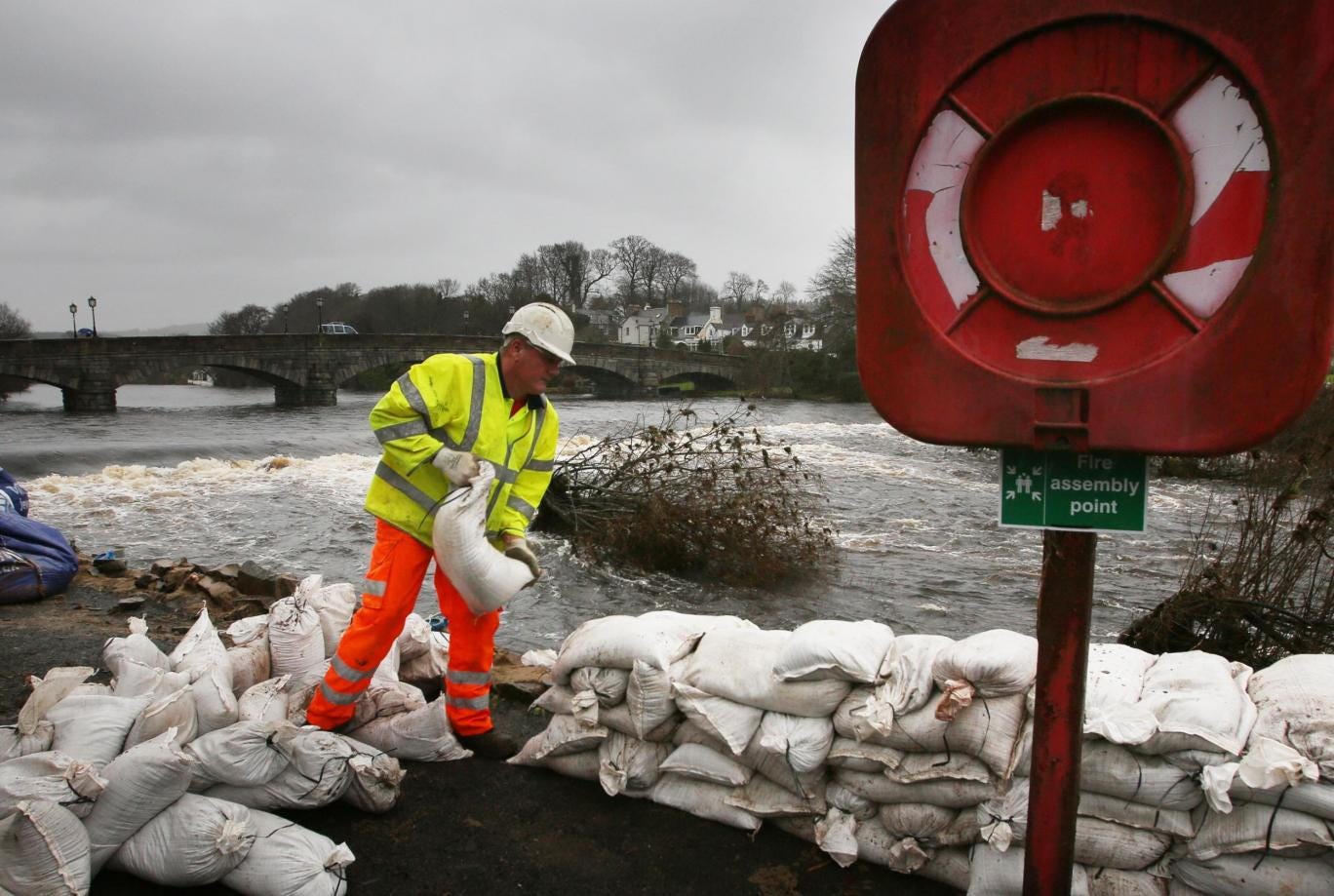 Workers build sand bag walls to try and hold back the river in Newton Stewart in the Scottish Borders following heavy rain from Storm Frank
