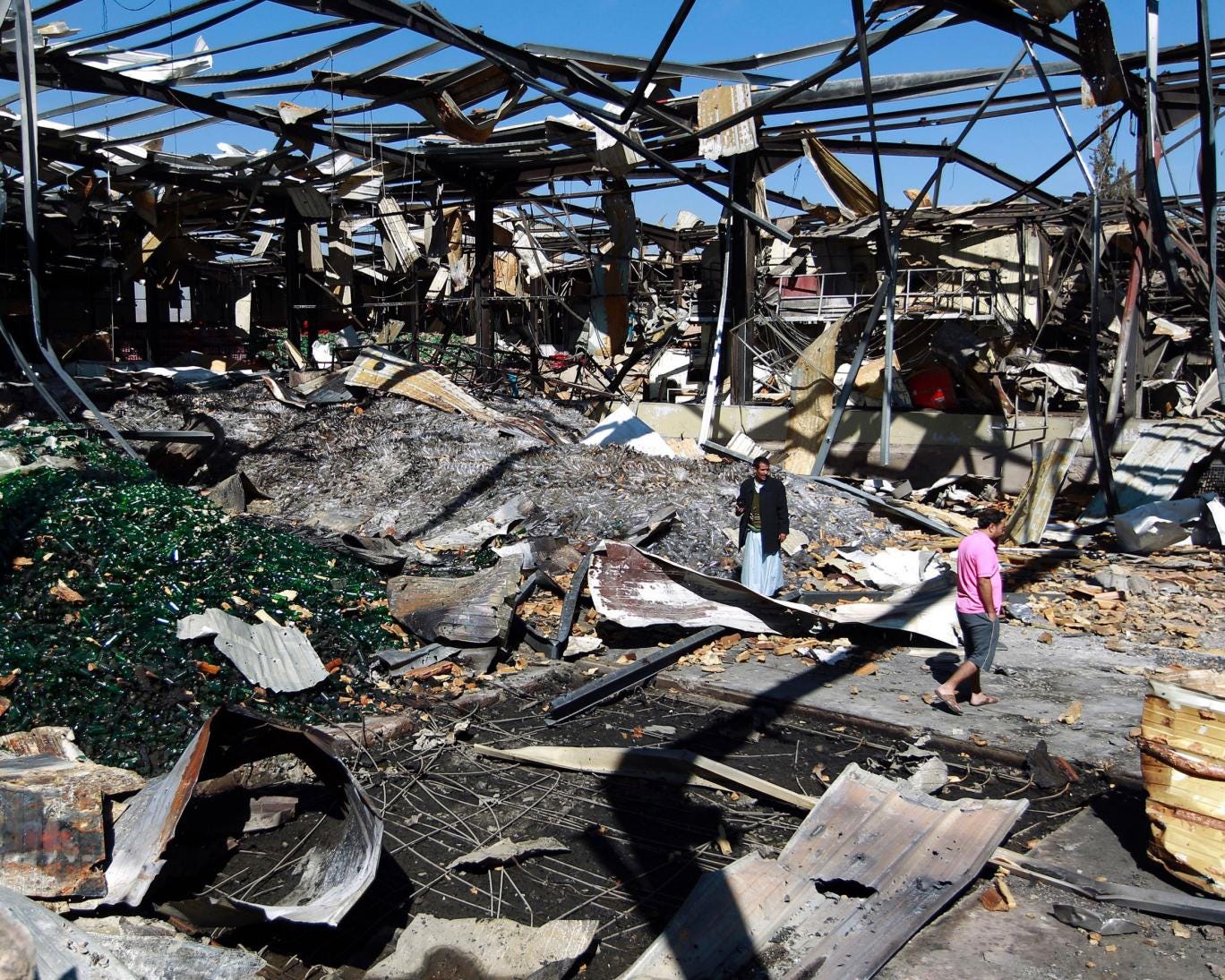 Yemeni workers inspect the damage at a Coca-Cola factory after it was reportedly destroyed by Saudi-led airstrikes in the capital Sanaa