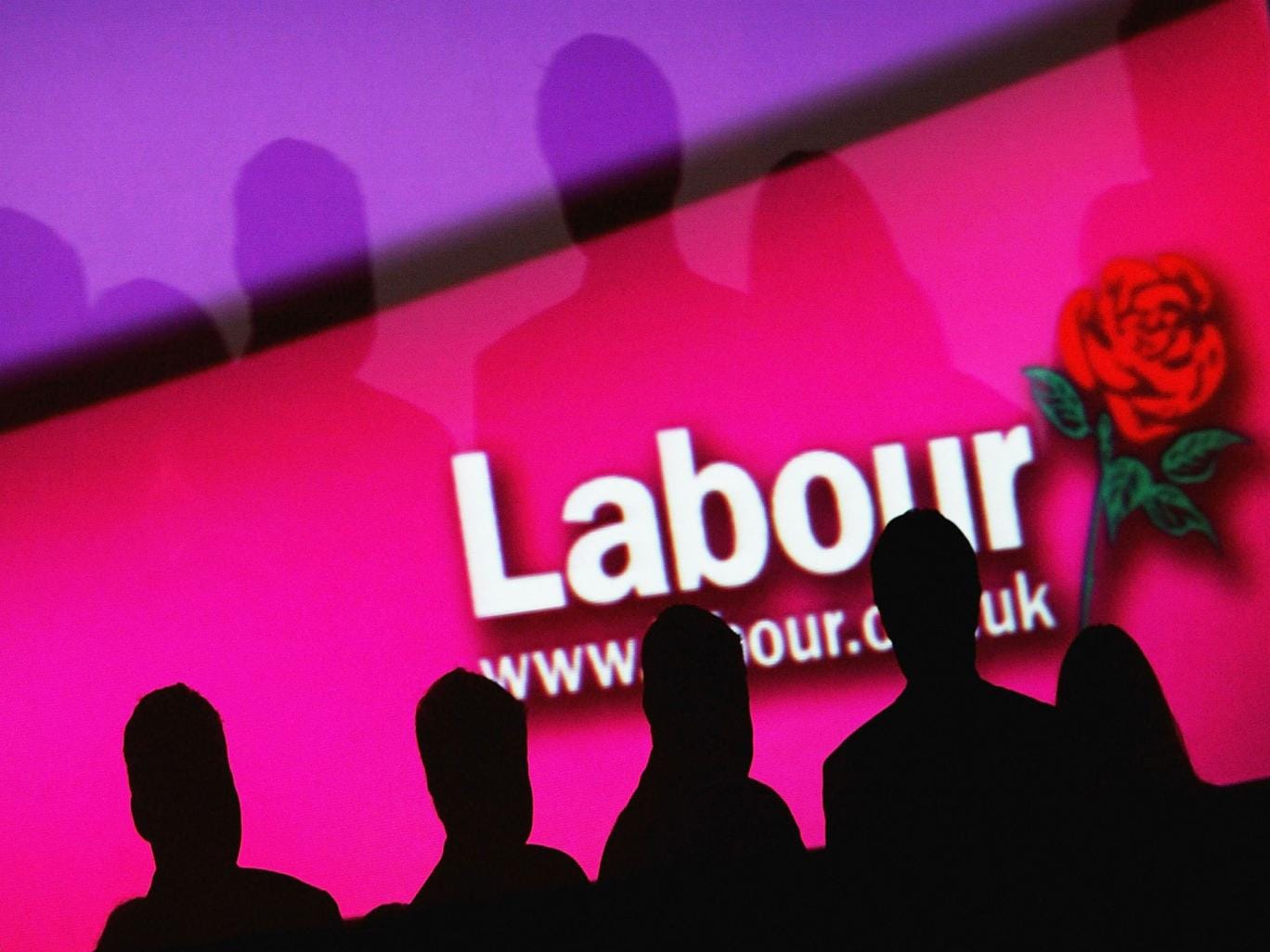 People are seen infront of a party logo during the Labour Party Annual Conference