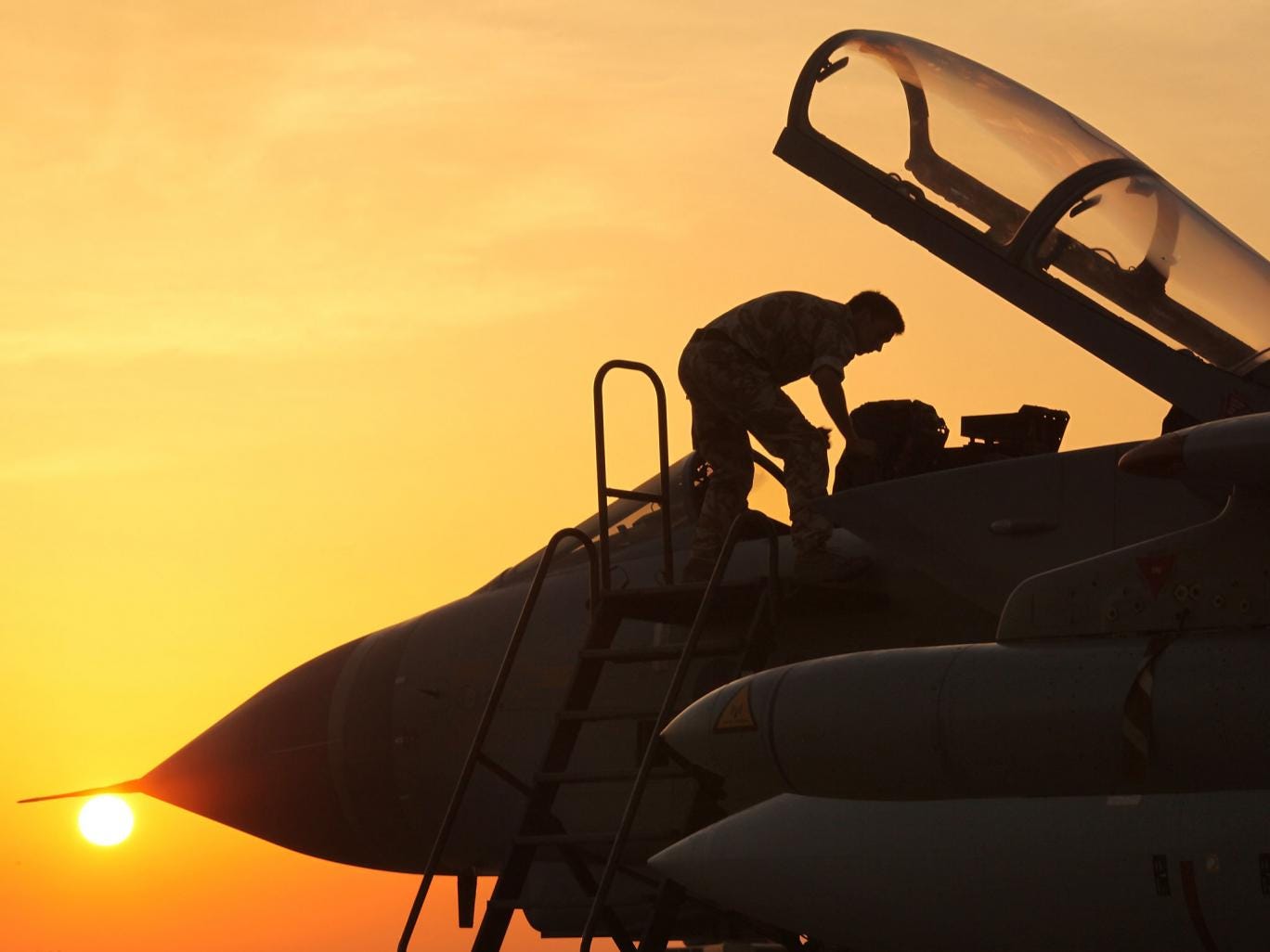 An engineer looks in the cockpit of a Royal Air Force (RAF) Tornado GR4 fighter bomber 