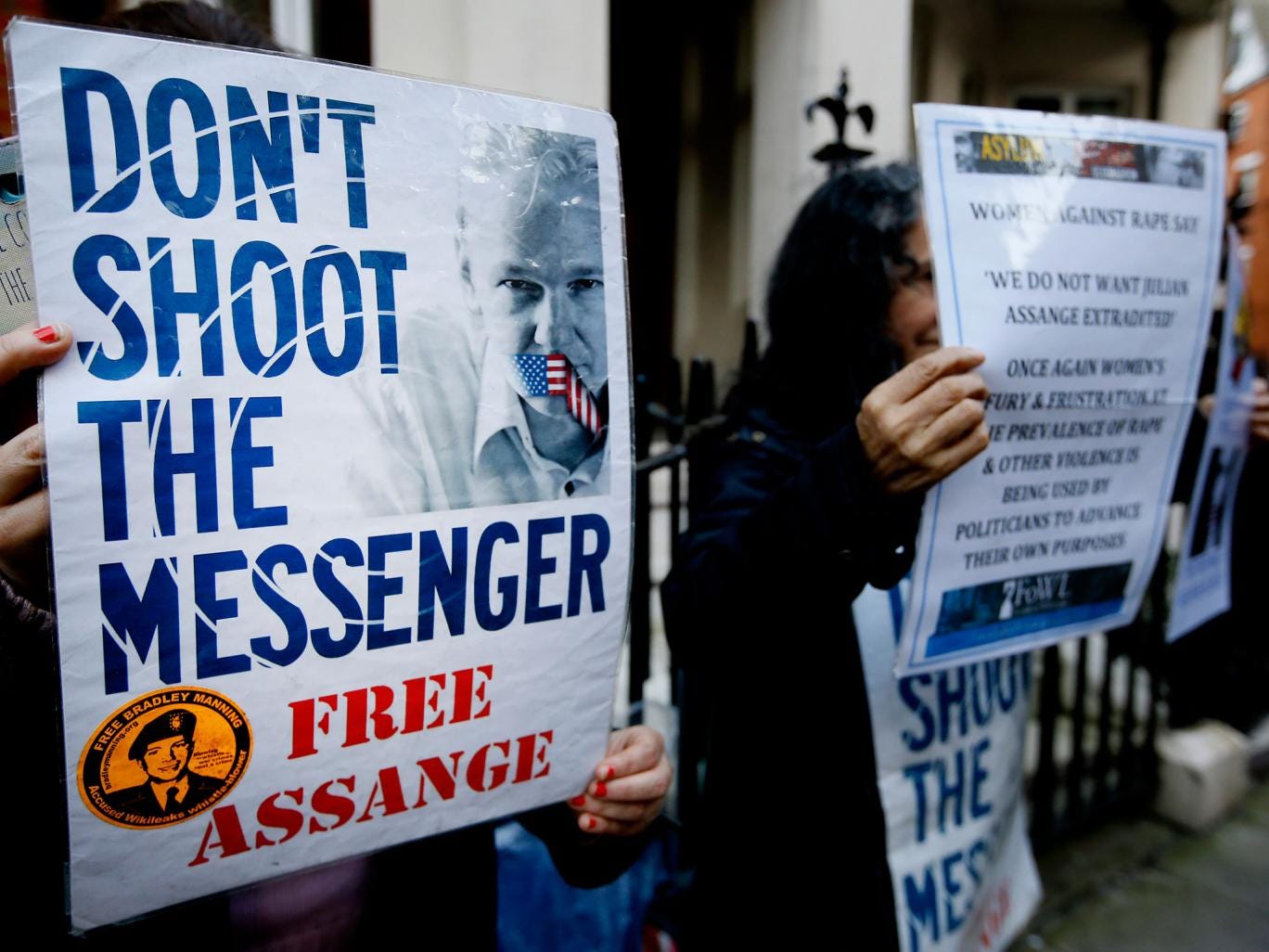 Demonstrators hold banners outside the Ecuadorean Embassy  in London, where Wikileaks founder Julian Assange is staying