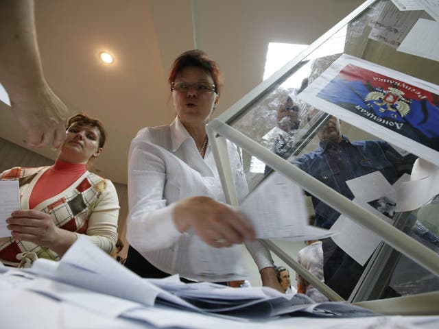 Members of a local election commission empty a ballot box as they start counting votes of the referendum on the status of Donetsk region in Donetsk 