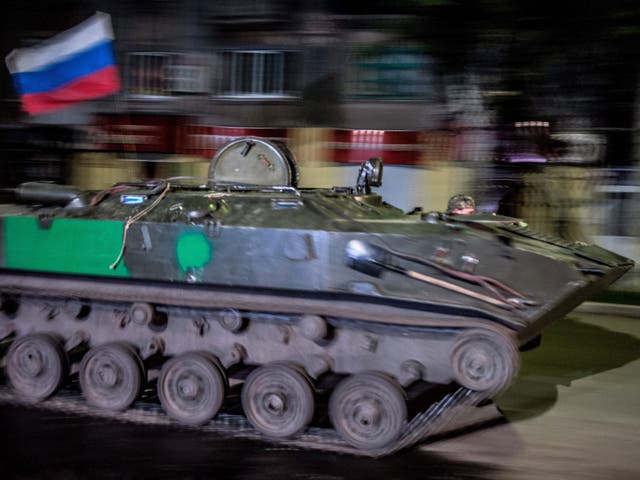 An Armoured Personnel Carrier (APC) with a Russian flag drives through the center of Slaviansk during the day of referendum organized by the so-called Donetsk People's Republic members in Slavyansk   