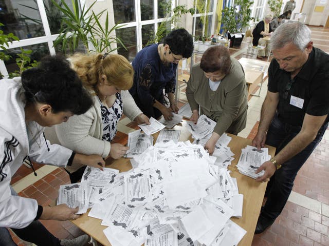 Members of a local election commission sort ballots as they start counting votes of referendum on the status of Luhansk region in Luhansk  