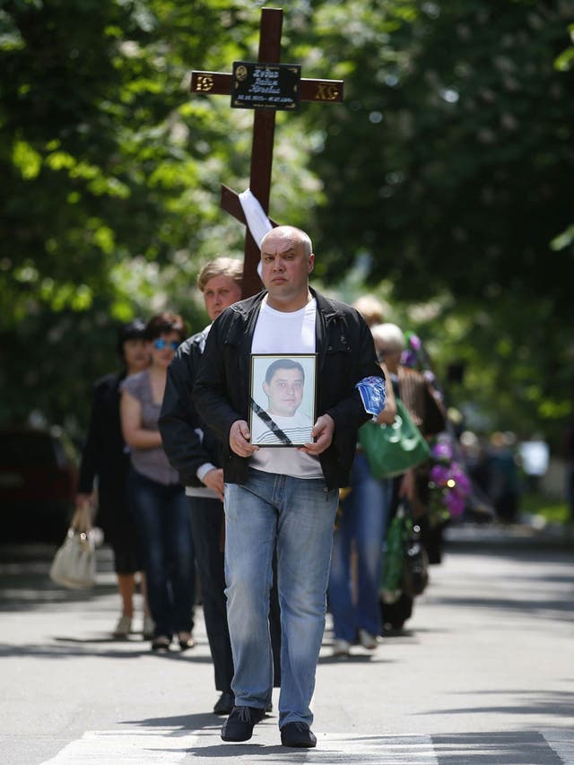 A man carries a portrait of pro-Russian activist Vadim Hudich, who was killed in a shooting incident at the head of a funeral procession in the eastern Ukranian town of Krasnoarmeisk  