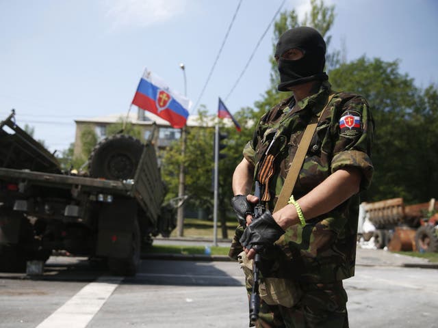 A member of a newly-formed pro-Russian armed group called the Russian Orthodox Army mans a barricade near Donetsk airport  