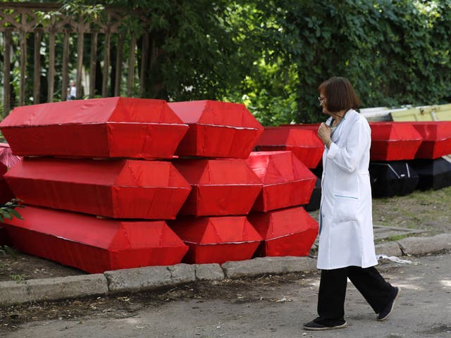 A medic looks at thirty coffins prepared for the funerals of pro-Russian rebels killed during heavy fighting at Donetsk airport, outside a Donetsk morgue 
