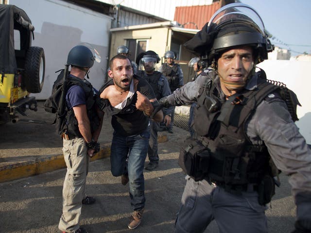 Israeli riot police arrest an Arab Israeli man during clashes that followed a protest against Israel's military offensive on the Gaza Strip, in the northern city of Nazareth 