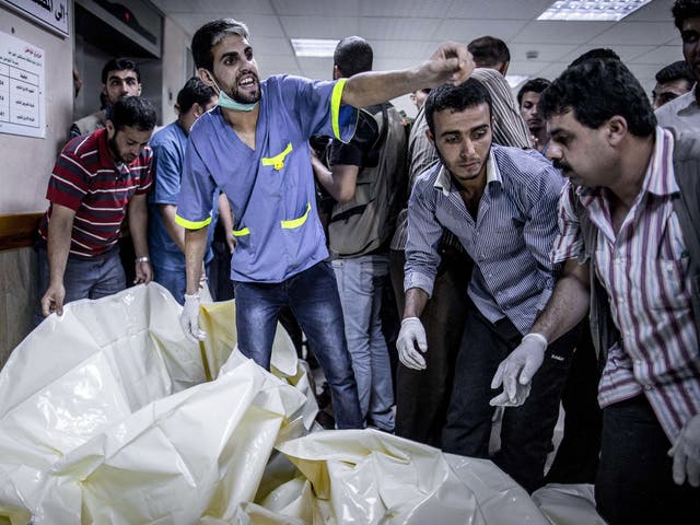 Palestinian medics from Gaza City's al-Shifa hospital react while body bags with the remain of ten children arrive after an Israeli air strike in Gaza City 