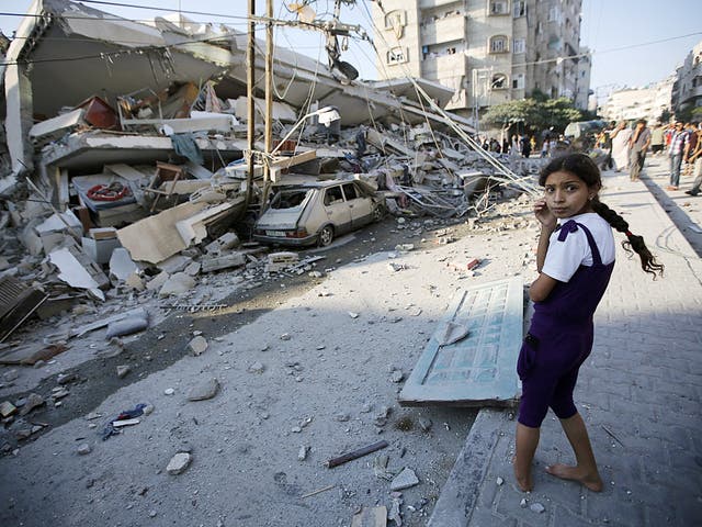 Palestinians inspect a destroyed house after an Israeli air strike in the Gaza City 