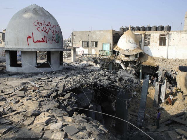 Palestinians look at the remains of a mosque, which police said was hit in an Israeli air strike, in Rafah in the southern Gaza Strip 