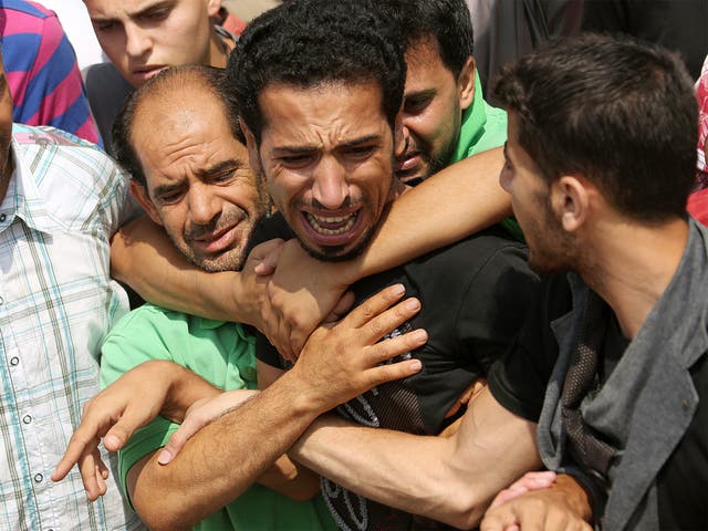 Mourning relatives of the Kelani family cry as they attend the funeral in Beit Lahiya, Gaza