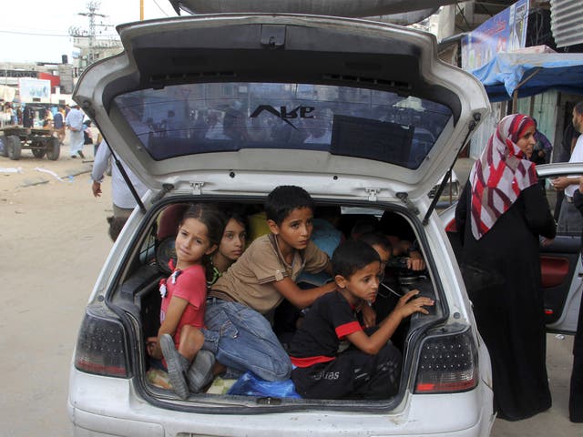 Palestinian families who fled their homes from east of Khan Younis in the southern Gaza Strip ride on a car in their way to the city of Khan Younis 