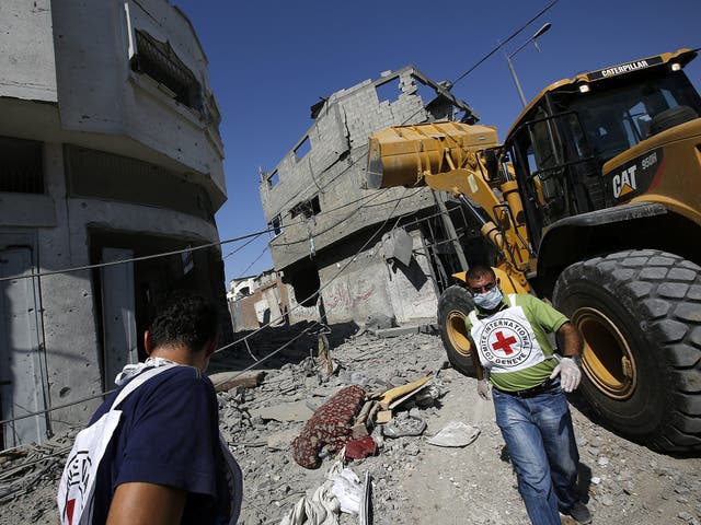 Red cross staff arrive to the damaged area in Al Shejaeiya neighbourhood, during an Israeli military operation in the east Gaza City 