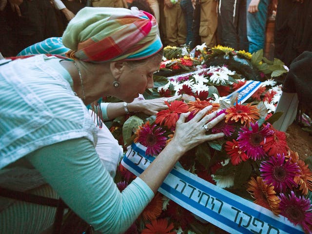 A mourner touches a wreath placed on the grave of fallen Israeli soldier Natan Cohen, killed during fighting in Gaza, during his funeral in the town of Modi'in, between Jerusalem and Tel Aviv  