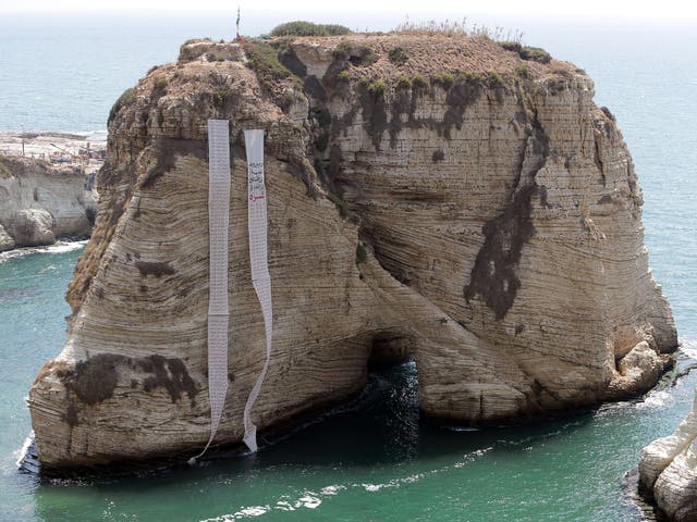 A banner depicting the names of Palestinians killed in Israel's ongoing assault on the Gaza Strip hangs on the landmark Pigeon Rock in Beirut's Rawshe seafront 