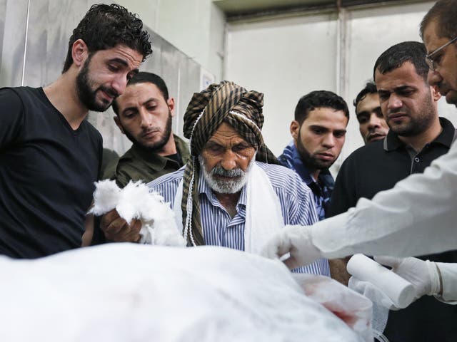Palestinian Ahmed Jadallah, sentrum, 75, prepares a body for burial at the morgue of Kamal Adwan hospital in Beit Lahiya, northern Gaza Strip
