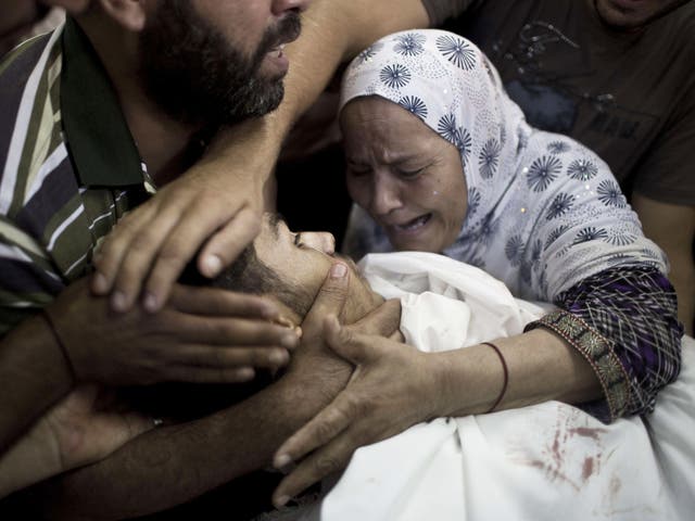 A Palestinian mother mourns over the body of her son, Abd al-Karim al-Shibari, who was killed after a UN school in the northern Beit Hanun district of the Gaza Strip was hit by an Israeli shell, at the morgue of the Kamal Adwan hospital in Beit Lahiya
