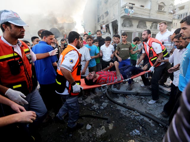 A Palestinian helps a relative, wounded in an Israeli strike in Gaza City