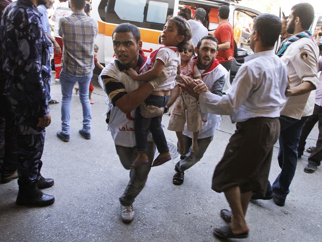 Palestinian medics run carrying children, wounded in an Israeli strike on a compound housing a U.N. school in Beit Hanoun, in the northern Gaza Strip, into the emergency room of the Kamal Adwan hospital in Beit Lahiya 