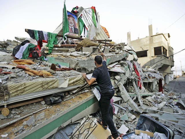 The rubble of the house of the Hamas leader, Ismail Haniyeh, – pictured in the poster, hit by a pre-dawn Israeli strike, in Gaza City 