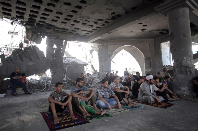 Palestinians attend Friday noon prayers in a destroyed mosque that was hit by Israeli strikes, in Gaza City