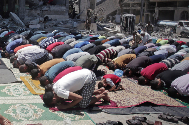 Palestinians attend Friday noon prayers next to a destroyed mosque was hit by Israeli strikes in Gaza City