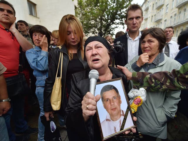 A woman holds a portrait of her dead son as she speaks during a rally in front of Ukrainian President Petro Poroshenko's office in Kiev