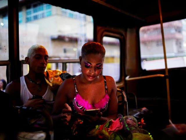 A dancer uses a hotspot from inside a bus before performing at the Carnival of Havana