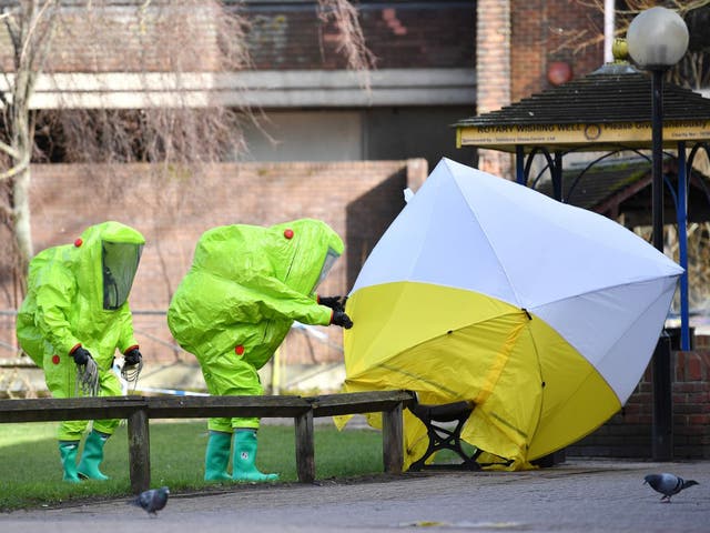 Members of the emergency services in hazard suits fix the tent over the bench where Sergei and Yulia Skripal were found unconscious on a park bench in Salisbury in March 2018.