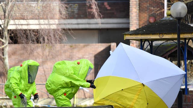 Members of the emergency services in hazard suits fix the tent over the bench where Sergei and Yulia Skripal were found unconscious on a park bench in Salisbury in March 2018.