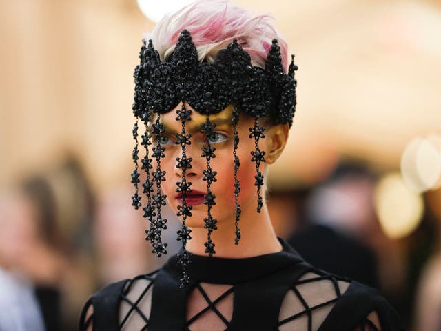 Cara Delevingne wears a dramatic all-black Dior Haute Couture dress and beaded veil