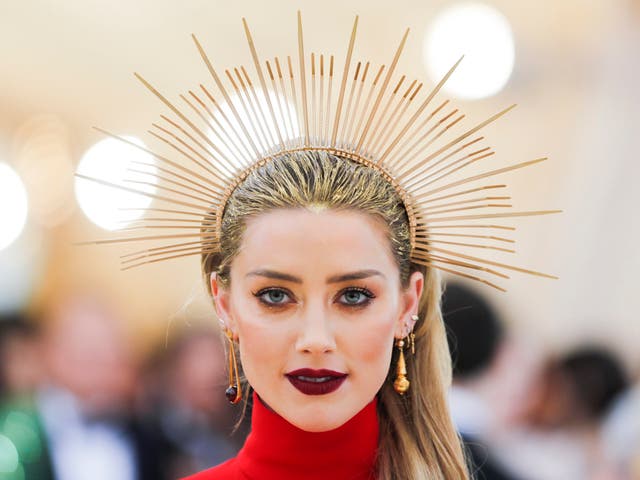 Amber Heard paired a Carolina Herrera scarlet gown with a gold halo headpiece 