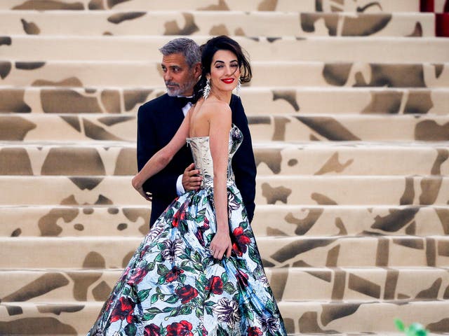 Amal Clooney wears a Richard Quinn corset dress and navy trousers while husband George Clooney opted for a traditional black tuxedo