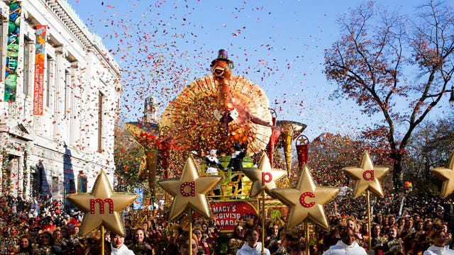 Performers walk in front of Macy's Tom Turkey float in the Thanksgiving Day Parade in New York