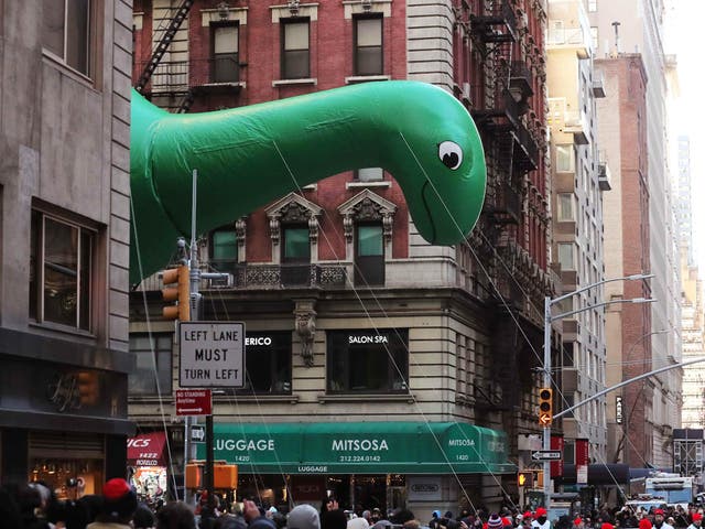 Sinclair's DINO balloon flies as the parade passes down 6th Avenue