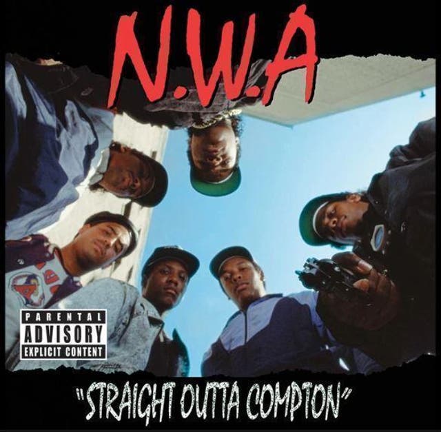 Six guys stare down toward the ground, one pointing a handgun right at the viewer. This is the cover art for Straight Outta Compton, the pioneering debut by NWA. The photographer was a 28-year-old white guy, Eric Poppleton, who was struggling to make ends meet after graduating from art school. He and his art director Kevin Hosman spent a day following the guys around alleys in LA, until Poppleton found a spot where he got on the ground and asked NWA’s members to stand over him, with one holding “what was hopefully an unloaded” gun. He had no idea the photograph would become one of the most iconic images in gangsta rap. Poppleton would go on to shoot four other NWA album covers.
