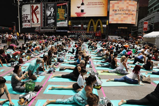 In New York, hundreds of people participate in yoga in Times Square to celebrate the arrival of summer 