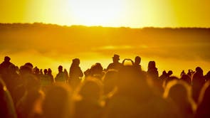 People turn to face the rising sun at Stonehenge at dawn on summer solstice of the longest day of the year at Stonehenge on June 21