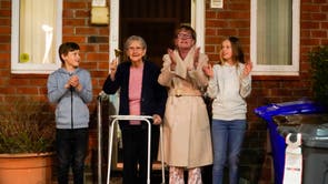 Barbara Leigh, vieilli 93, (second left) rings a bell for the NHS, with her family who are all staying together throughout the lockdown, from their front garden across the road from Wythenshawe Hospital in Manchester