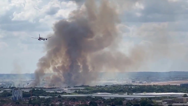 De la fumée s'échappe d'un incendie près de l'aéroport d'Heathrow alors que l'avion atterrit